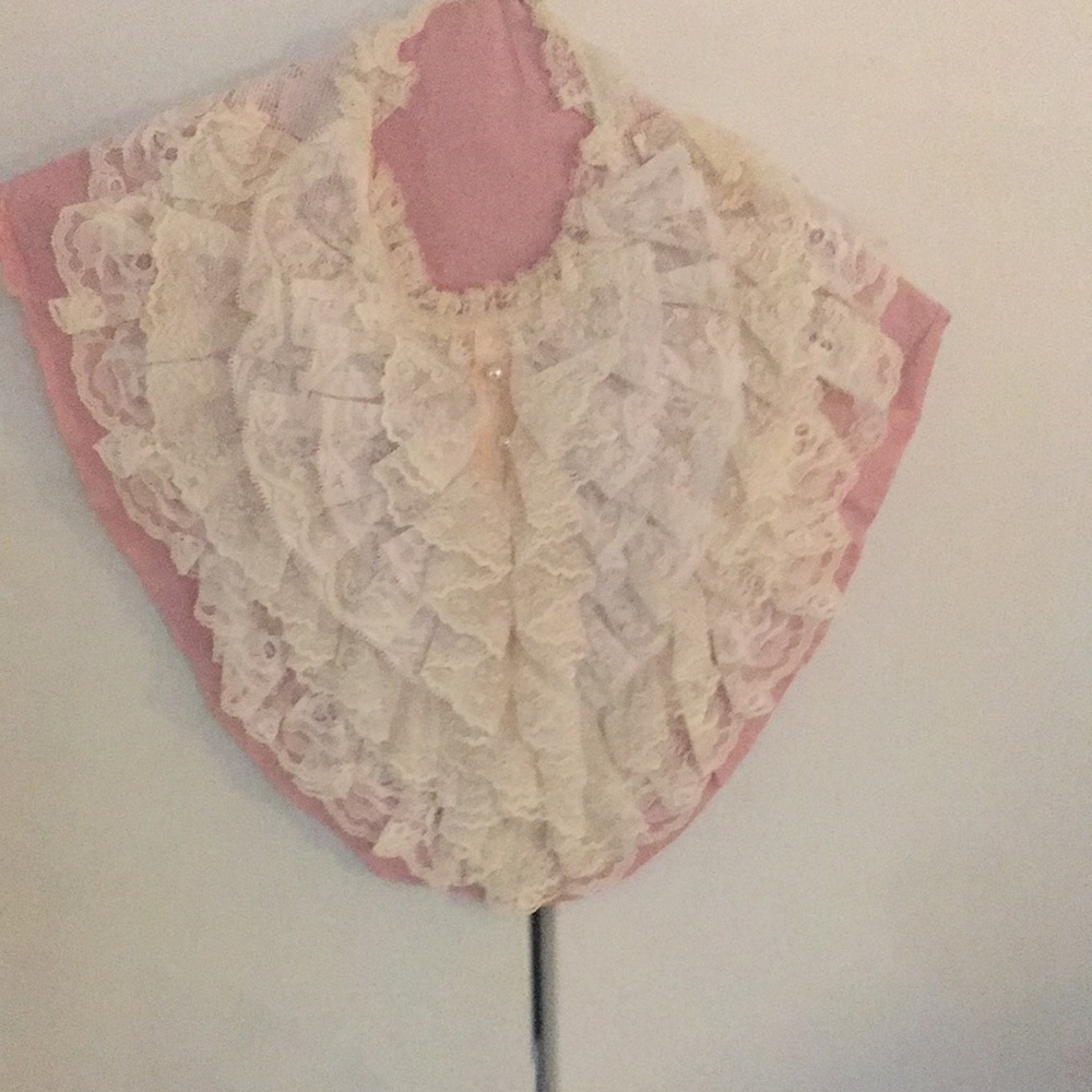 Exquisite lace bib with five rows of lace and pearl buttons from top to bottom.